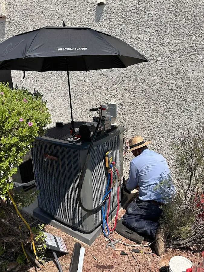 HVAC technician performing outdoor AC maintenance in Hoosick